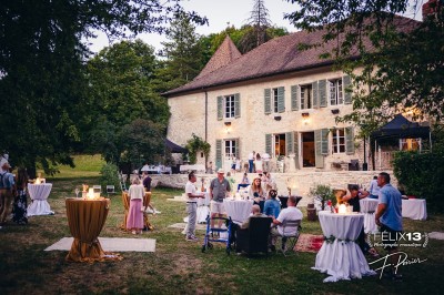 Plaque en pierre gravée avec des inscriptions dorées et un motif de croix ailée au-dessus du texte.
