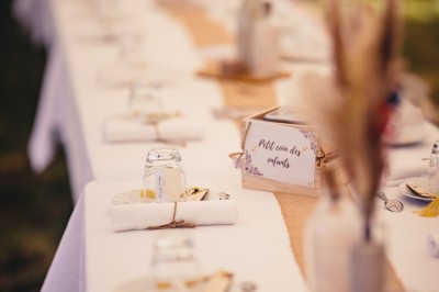 Plaque en pierre gravée avec des inscriptions dorées et un motif de croix ailée au-dessus du texte.