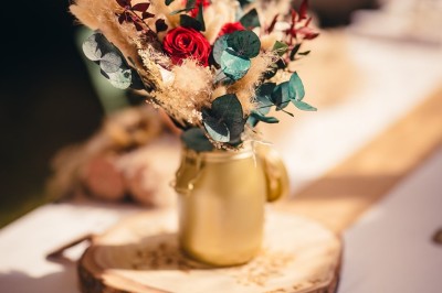 Plaque en pierre gravée avec des inscriptions dorées et un motif de croix ailée au-dessus du texte.
