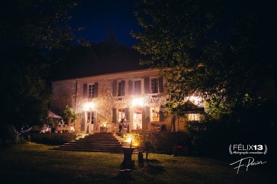 Plaque en pierre gravée avec des inscriptions dorées et un motif de croix ailée au-dessus du texte.