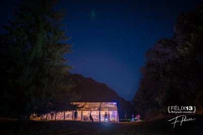 Plaque en pierre gravée avec des inscriptions dorées et un motif de croix ailée au-dessus du texte.
