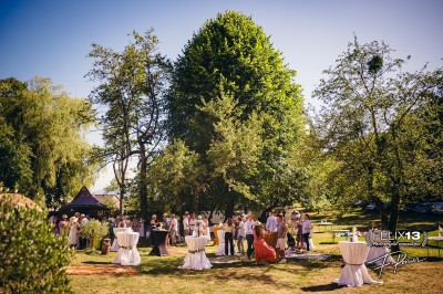 Plaque en pierre gravée avec des inscriptions dorées et un motif de croix ailée au-dessus du texte.