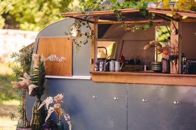 Plaque en pierre gravée avec des inscriptions dorées et un motif de croix ailée au-dessus du texte.