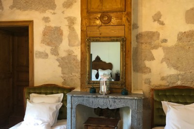 Plaque en pierre gravée avec des inscriptions dorées et un motif de croix ailée au-dessus du texte.