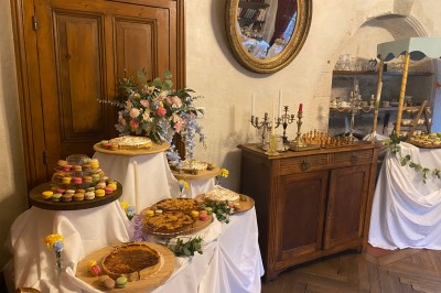 Plaque en pierre gravée avec des inscriptions dorées et un motif de croix ailée au-dessus du texte.