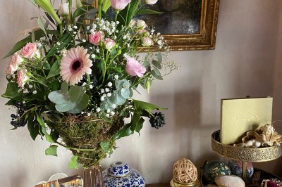 Plaque en pierre gravée avec des inscriptions dorées et un motif de croix ailée au-dessus du texte.