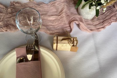 Plaque en pierre gravée avec des inscriptions dorées et un motif de croix ailée au-dessus du texte.