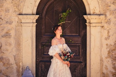 Plaque en pierre gravée avec des inscriptions dorées et un motif de croix ailée au-dessus du texte.