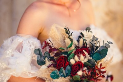 Plaque en pierre gravée avec des inscriptions dorées et un motif de croix ailée au-dessus du texte.