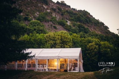 Plaque en pierre gravée avec des inscriptions dorées et un motif de croix ailée au-dessus du texte.