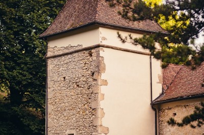 Plaque en pierre gravée avec des inscriptions dorées et un motif de croix ailée au-dessus du texte.