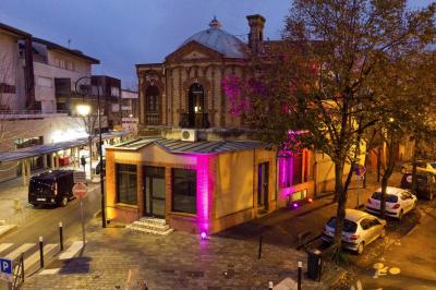 Cuisine moderne avec îlot central noir, chaises hautes, meubles rouges, électroménagers intégrés et carrelage blanc.