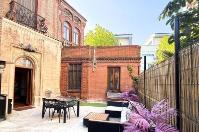 Cuisine moderne avec îlot central noir, chaises hautes, meubles rouges, électroménagers intégrés et carrelage blanc.