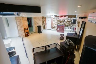 Cuisine moderne avec îlot central noir, chaises hautes, meubles rouges, électroménagers intégrés et carrelage blanc.