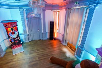 Cuisine moderne avec îlot central noir, chaises hautes, meubles rouges, électroménagers intégrés et carrelage blanc.