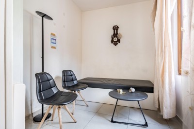 Des professionnels discutent en petits groupes autour de tables hautes dans une cour extérieure ensoleillée.