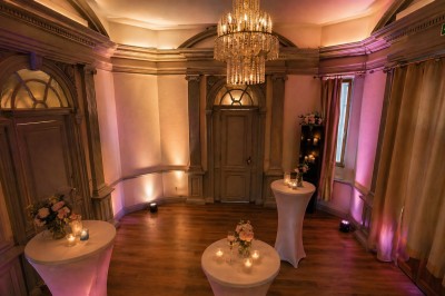Des professionnels discutent en petits groupes autour de tables hautes dans une cour extérieure ensoleillée.