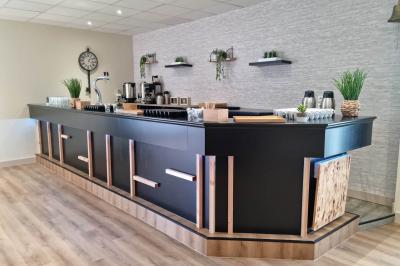 Lit double avec couvre-lit clair dans une chambre lumineuse, équipée d'une lampe sur pied et d'un lit superposé.