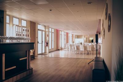 Lit double avec couvre-lit clair dans une chambre lumineuse, équipée d'une lampe sur pied et d'un lit superposé.