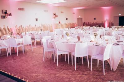 Lit double avec couvre-lit clair dans une chambre lumineuse, équipée d'une lampe sur pied et d'un lit superposé.