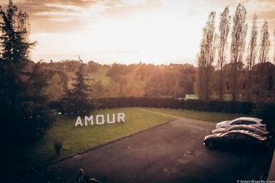 Lit double avec couvre-lit clair dans une chambre lumineuse, équipée d'une lampe sur pied et d'un lit superposé.