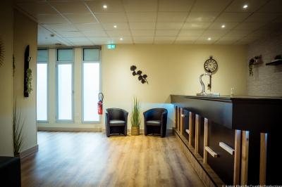 Lit double avec couvre-lit clair dans une chambre lumineuse, équipée d'une lampe sur pied et d'un lit superposé.