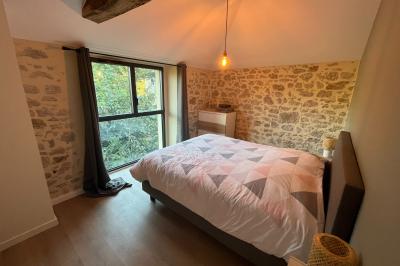 Groupe de personnes rassemblées sur une terrasse en bord de rivière, entourée de verdure et décorée de guirlandes lumineuses.