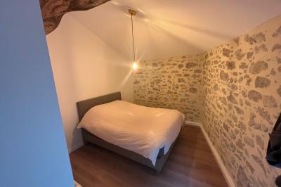 Groupe de personnes rassemblées sur une terrasse en bord de rivière, entourée de verdure et décorée de guirlandes lumineuses.