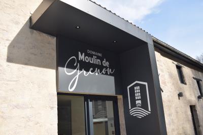 Groupe de personnes rassemblées sur une terrasse en bord de rivière, entourée de verdure et décorée de guirlandes lumineuses.