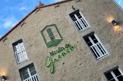 Groupe de personnes rassemblées sur une terrasse en bord de rivière, entourée de verdure et décorée de guirlandes lumineuses.