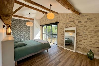 Groupe de personnes rassemblées sur une terrasse en bord de rivière, entourée de verdure et décorée de guirlandes lumineuses.