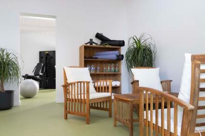 Table en bois avec assiettes d'huîtres, verres de vin blanc, citron et bouteille, dans un jardin ensoleillé avec fauteuil.