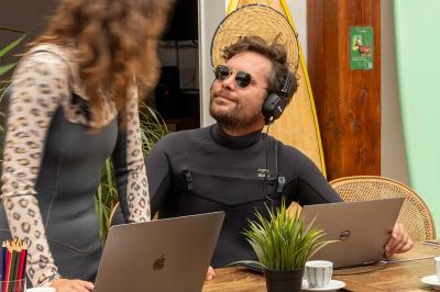 Table en bois avec assiettes d'huîtres, verres de vin blanc, citron et bouteille, dans un jardin ensoleillé avec fauteuil.