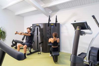 Salle de bain lumineuse avec douche vitrée, lavabo blanc, miroir, et accessoires de toilette.