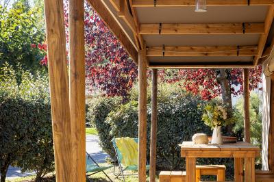Salle de bain lumineuse avec douche vitrée, lavabo blanc, miroir, et accessoires de toilette.