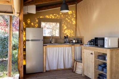 Salle de bain lumineuse avec douche vitrée, lavabo blanc, miroir, et accessoires de toilette.