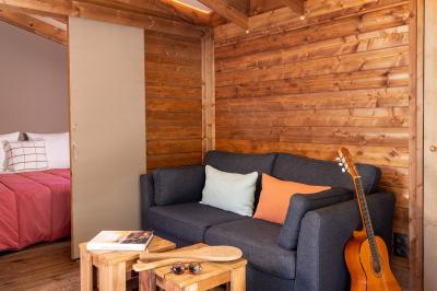 Salle de bain lumineuse avec douche vitrée, lavabo blanc, miroir, et accessoires de toilette.