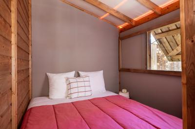 Salle de bain lumineuse avec douche vitrée, lavabo blanc, miroir, et accessoires de toilette.
