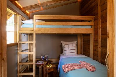 Salle de bain lumineuse avec douche vitrée, lavabo blanc, miroir, et accessoires de toilette.