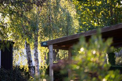 Salle de bain lumineuse avec douche vitrée, lavabo blanc, miroir, et accessoires de toilette.
