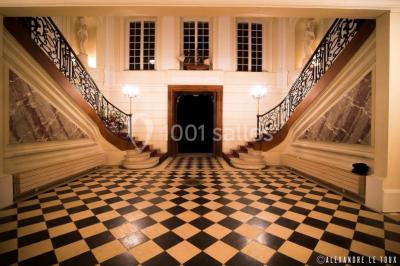 Trois cerfs dans une clairière, deux broutant l'herbe et un levant la tête près d'une forêt dense.