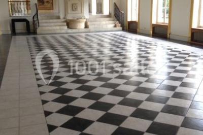 Trois cerfs dans une clairière, deux broutant l'herbe et un levant la tête près d'une forêt dense.