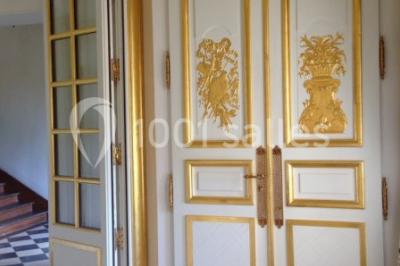 Trois cerfs dans une clairière, deux broutant l'herbe et un levant la tête près d'une forêt dense.