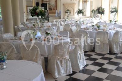 Trois cerfs dans une clairière, deux broutant l'herbe et un levant la tête près d'une forêt dense.