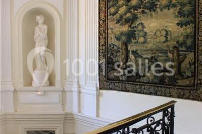 Trois cerfs dans une clairière, deux broutant l'herbe et un levant la tête près d'une forêt dense.