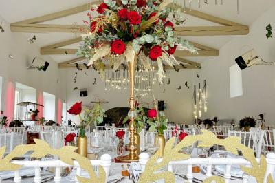 Table décorée pour un événement avec nappes en lin, fleurs roses et blanches, verres à vin et petits pots en verre.