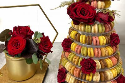 Table décorée pour un événement avec nappes en lin, fleurs roses et blanches, verres à vin et petits pots en verre.