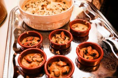 Buffet avec des amuse-bouches variés présentés sur des plateaux en bois et des verrines en arrière-plan.