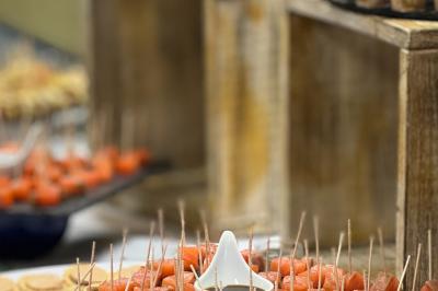 Buffet avec des amuse-bouches variés présentés sur des plateaux en bois et des verrines en arrière-plan.