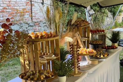 Buffet avec des amuse-bouches variés présentés sur des plateaux en bois et des verrines en arrière-plan.